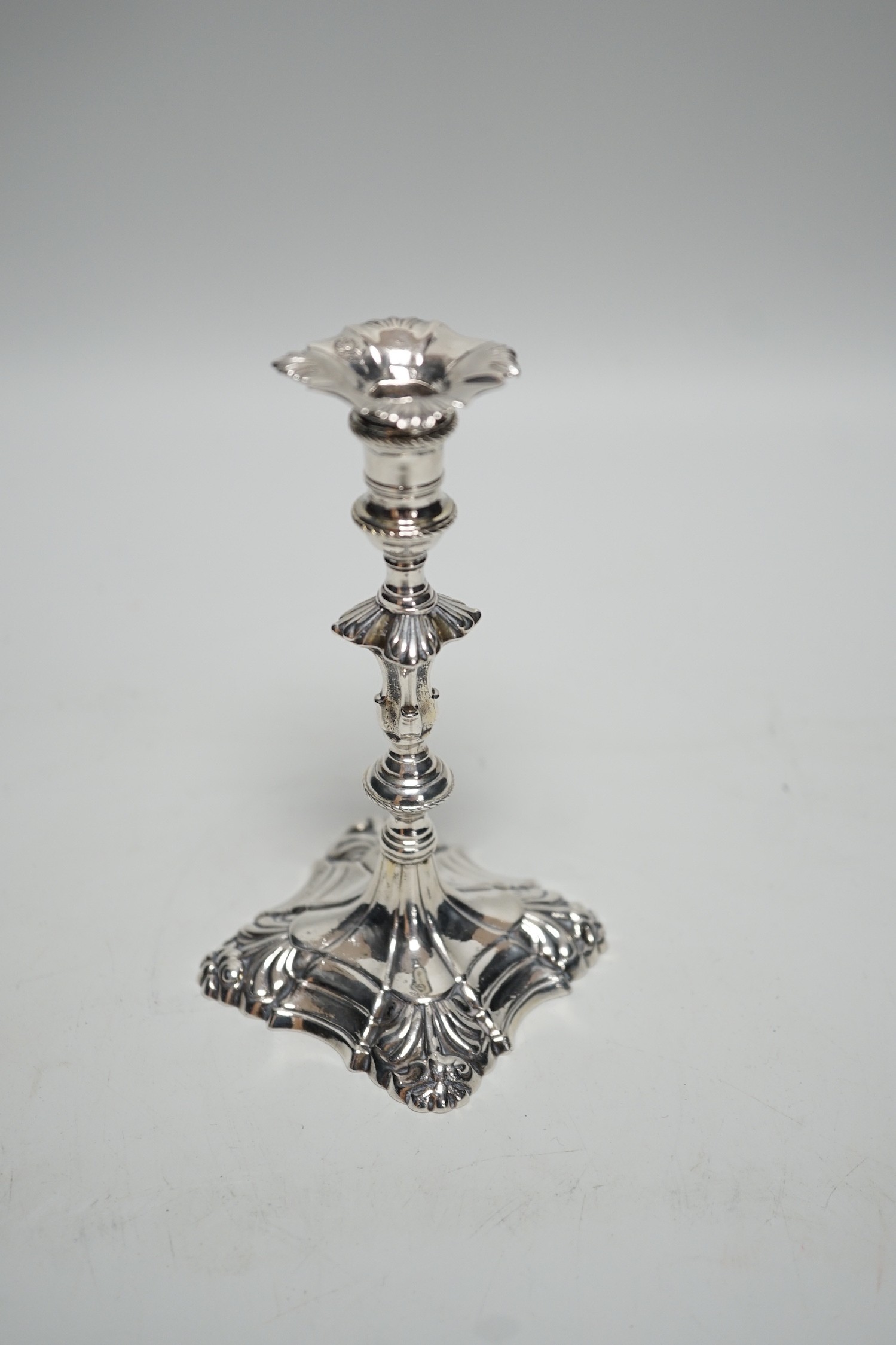 A George III cast silver taper stick, with turned knopped stem and engraved crest, maker, JH, London, 1764, 13.3cm, 4.7oz